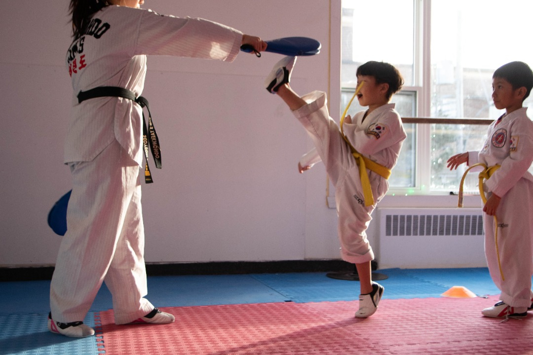 Kid in the Junior class doing a high kick at Kim's Taekwondo in Montreal